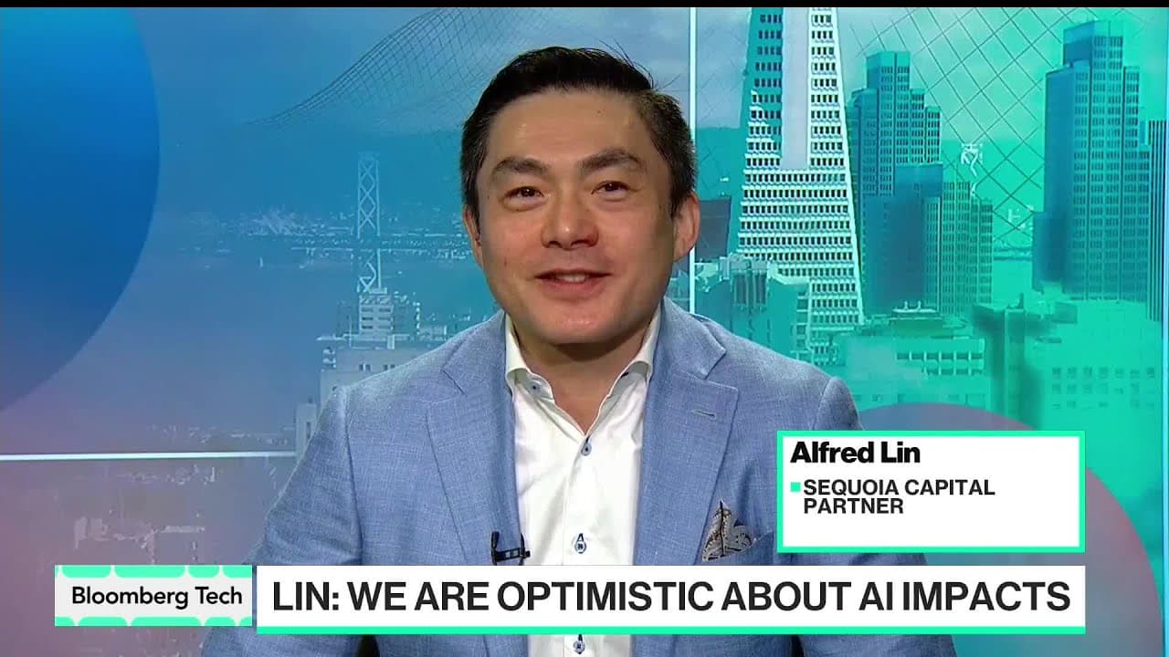 Alfred Lin of Sequoia Capital discussing AI's future impact in a studio setting, with city skyline background